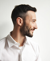 Obraz premium Profile portrait of a smiling man with short dark hair and beard wearing a white collared shirt