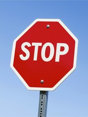 The Symbolic Red Beacon: An eye-level shot captures a bold stop sign, its vibrant red hue contrasting with a clear, sunlit azure sky. It serves as a visual cue to halt, embodying safety and authority.