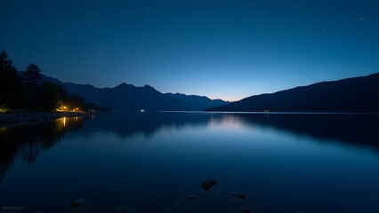 Fototapeta premium Still Lake Reflecting Starry Night Sky with Mountain Silhouette at Twilight 