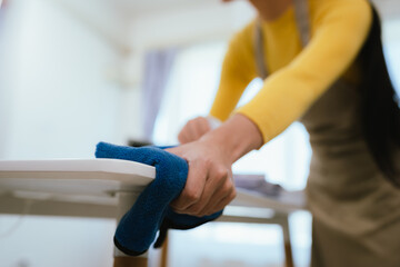 Professional cleaner wearing gloves performs household chores with cleaning equipment, ensuring...