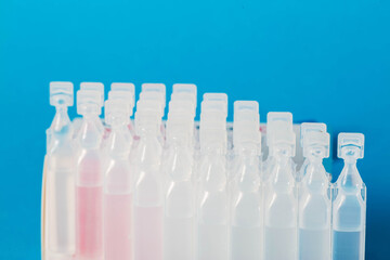 Tubes with probiotic and new generation metabiotic on a blue background. The concept of treating diseases of the gastrointestinal tract with succinic acid and bacteria. Copy space for text