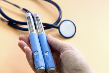 Women's hands holding Insulin injection pen for diabetics and weight loss.