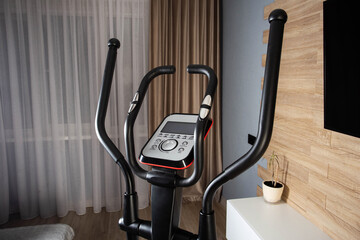 New modern elliptical trainer at home in the exercise room, close-up