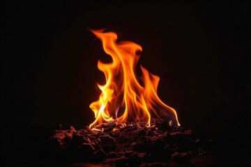 flames are lit in the dark on a pile of rocks
