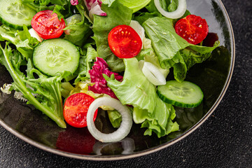 Vegetable salad tomato, cucumber, lettuce, green leaf lettuce, onion appetizer vegetable dish fresh gourmet food background rustic food top view copy space keto and paleo diet vegetarian vegan food