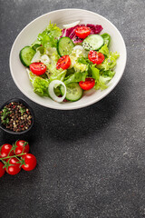 Vegetable salad tomato, cucumber, lettuce, green leaf lettuce, onion appetizer vegetable dish fresh gourmet food background rustic food top view copy space keto and paleo diet vegetarian vegan food