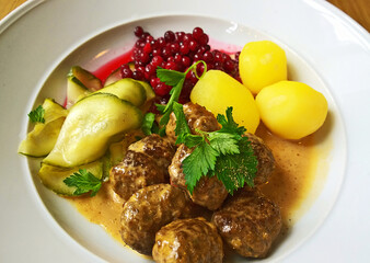 Typical Swedish meatballs with potatoes wild berries and cocumbers