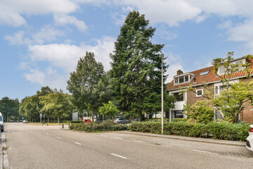 A serene residential street featuring lush trees, well-kept houses, and a clear sky. It showcases the charm of suburban life and peaceful living environments.