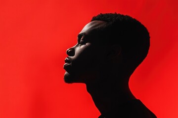 Side profile of contemplative African American man against vibrant red background, eyes closed and expressing serenity and introspection