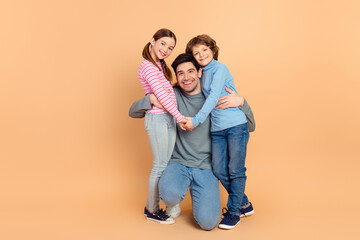 Happy family of three posing together, featuring a father with his son and daughter, expressing love and bonding