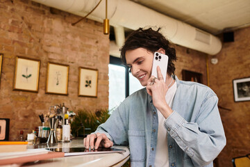 Charming young man enjoying a casual moment at the cafe while engaged in a phone conversation