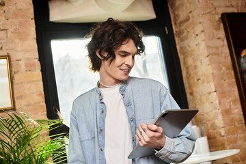 Young, handsome man enjoying leisure time at a vibrant cafe while exploring digital content