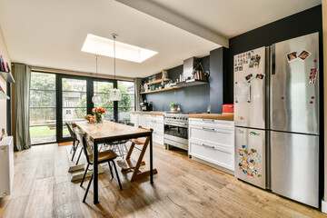 A beautifully designed modern kitchen featuring a spacious layout, large windows for abundant...