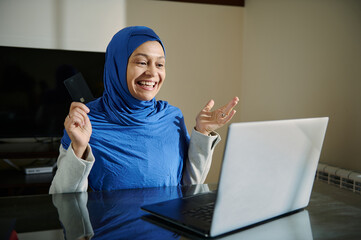 Woman Shopping Online Using Laptop and Credit Card Smiling Happily