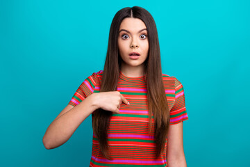 Portrait of a young woman in vibrant attire expressing surprise against a teal background, with...