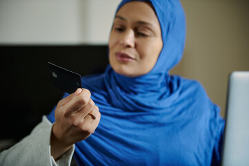 Woman Evaluating Credit Card in Professional Setting Focused on Modern Transactions