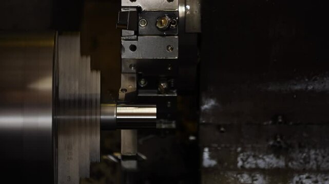Closeup CNC controlled metal lathe tool turning with aluminum rod