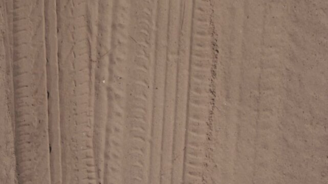 Tire tread prints on the ground. tire tracks. Tire tracks on a sandy road. Car tread prints on the sand. Footprint and traces of an off-road car tires in the mud. tire prints in the snow.