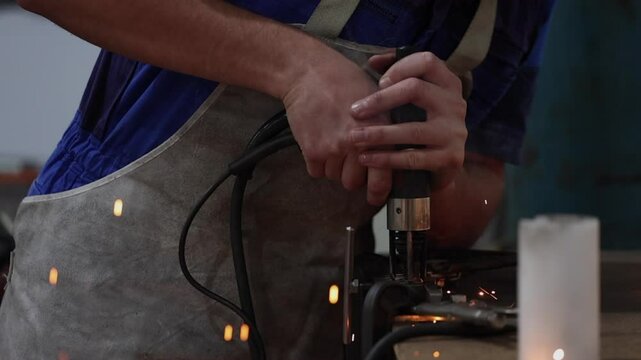 Hot sparks fly from stud welder as bolt is welded to steel frame