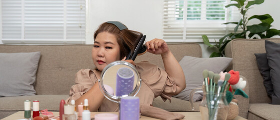 Hair Styling and Beauty Care. A woman using a hair straightener, focusing on her hairstyle in a...