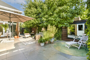 A beautifully designed outdoor patio featuring comfortable seating, lush plants, and a welcoming...