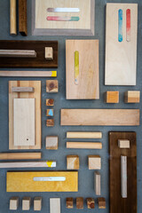 Flat lay of various wood and plywood pieces on concrete texture. Carpentry background.