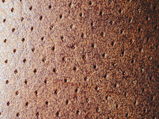 Macro texture of light brown leather, leather background and small hole