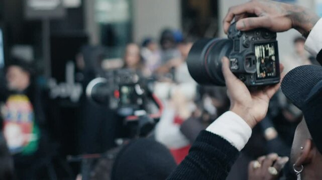 Photographer adjusting camera settings during public event