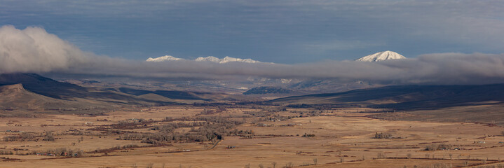 Ohio Valley with snow capped Carbon Peak and the Anthracite Range rising above the clouds.  Captured outside of Gunnison Colorado during late fall.