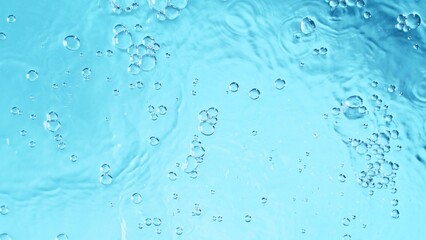 Transparent blue colored clear calm water surface texture with splashes and bubbles. Trendy abstract nature background.