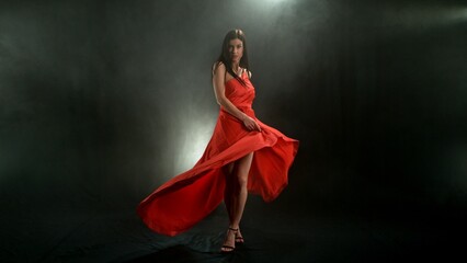 Woman in red dress dancing with flying fabric, Fashion Model Girl Posing with waving cloth