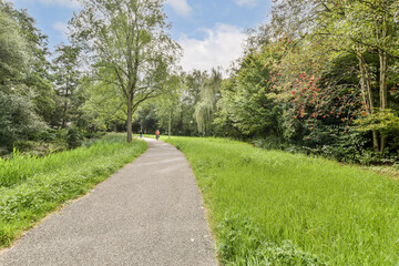 A tranquil pathway surrounded by lush greenery and trees, ideal for walking or jogging, inviting nature lovers to explore.