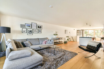 A stylish modern living room featuring a comfortable sofa, decorative artworks on the walls, and an open layout with natural lighting.