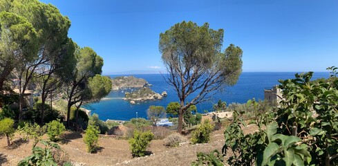 Panoramic view of Isola Bella from Taormina, with mediterranean vegetation, blue sea, and clear sky