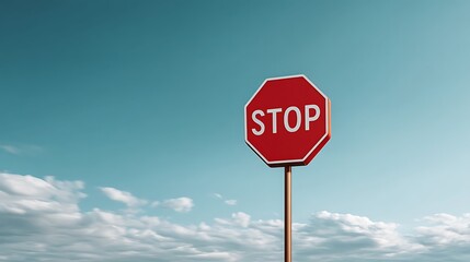 Obraz premium Bright Red Stop Sign with Blue Sky and White Clouds in the Background Under Daylight Conditions