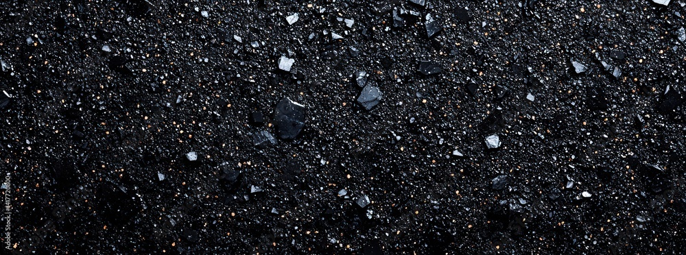 Poster a close-up of a textured, dark surface featuring small, shiny fragments that create a striking visua