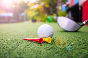 Golf Ball, Tees, and Club on Green Turf in Soft Morning Light