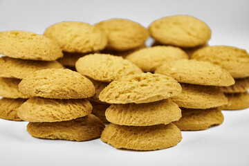 A group of sugar cookies are neatly stacked on top of each other on a white background..Close-up