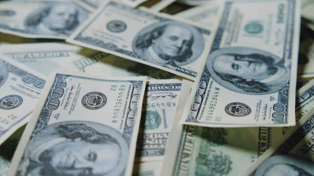 A Close-Up, Slow Motion Footage of One Hundred Dollar Bills from the United States. This Footage Focuses on the Details of U.S. Currency, Perfect for Financial and Economic Content. 