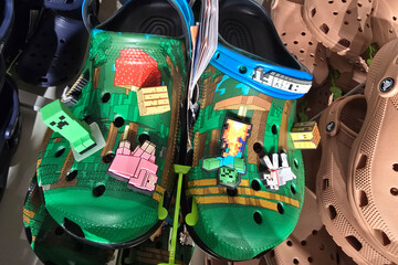 Fototapeta premium Kuala Lumpur, Malaysia - Mar 30, 2025: Green Crocs featuring Minecraft-themed Jibbitz charms, including pixelated characters and blocks, displayed in a Crocs store.