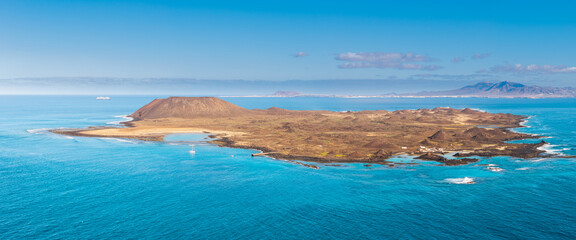 Aerial panoramic view of the beautiful secluded natural bay and the stunning small volcanic island of Los Lobos near Corralejo in Fuerteventura Spain