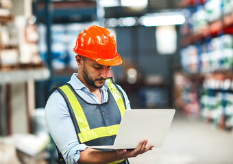 caucasian warehouse worker checking using laptop. caucasian man wearing safety examine storage area with notebook document. supervisor guy wear helmet safety vest at workplace inspect stock by laptop