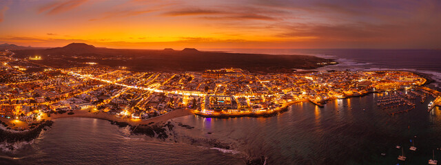 Spectacular aerial panoramic landscape image of the evening sunset sky at golden hour over the town of Corralejo, Fuerteventura, Canary Islands, Spain