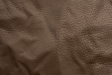 Background made of genuine brown leather. Material. Texture of colored wrinkled leather