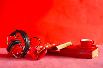 audio book concept with row of books and vintage headphone on red background.Education,inspiration,relaxation,literature concept.Free copy space.