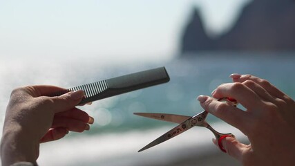 Scissors Comb Haircut Hands cut hair on sunny beach day for hairstyling demonstration closeup