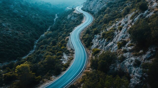 Winding mountain road through lush green landscape.