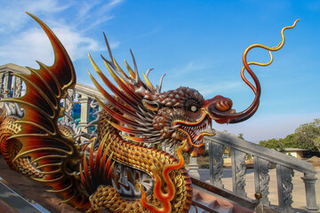 A detailed Chinese dragon statue decorates the entrance of a traditional temple.