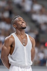 Olympic gymnast wearing a white t-shirt and a silver medal, smiling and looking at the sky after winning the medal