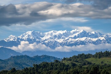 Naklejka premium Snowy mountain range, lush valley, dramatic clouds